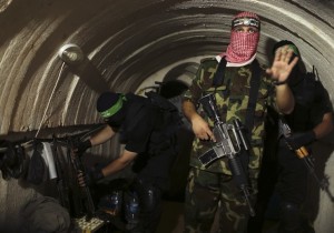 A Palestinian fighter from the Izz el-Deen al-Qassam Brigades, the armed wing of the Hamas movement, gestures inside an underground tunnel in Gaza August 18, 2014. A rare tour that Hamas granted to a Reuters reporter, photographer and cameraman appeared to be an attempt to dispute Israel's claim that it had demolished all of the Islamist group's border infiltration tunnels in the Gaza war. Picture taken August 18, 2014. REUTERS/Mohammed Salem (GAZA - Tags: POLITICS CONFLICT TPX IMAGES OF THE DAY) - RTR42YJW